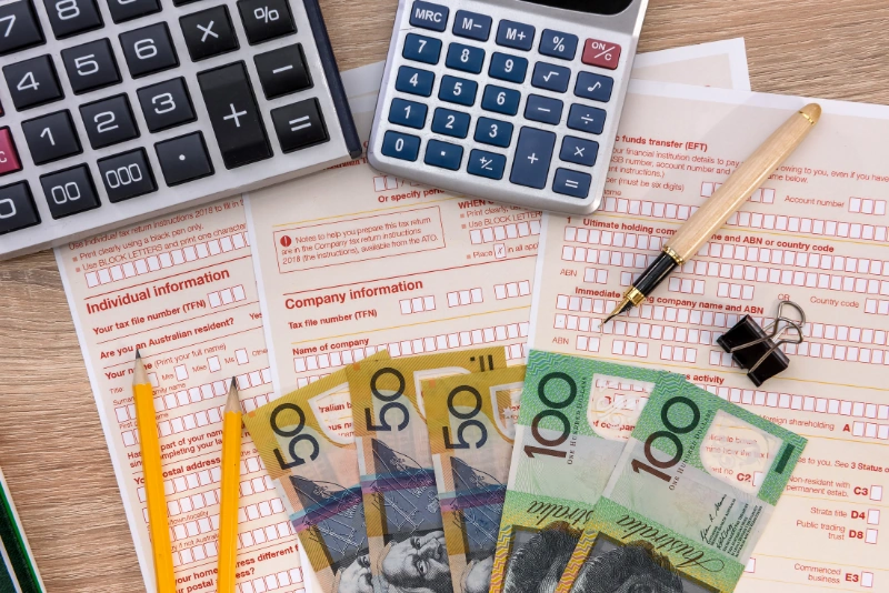 Australian tax return forms with calculator and cash for retirement tax planning