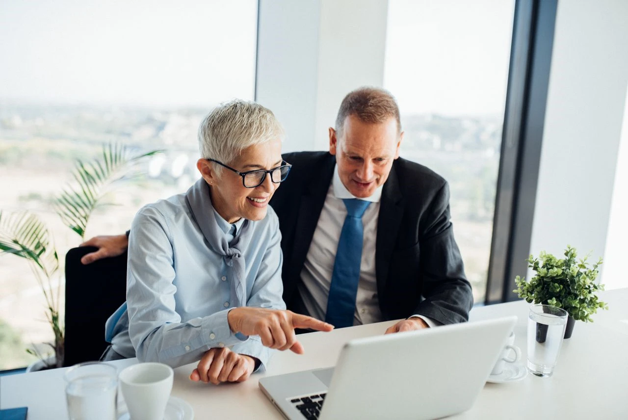 Business professionals discussing property investment tax strategies on laptop